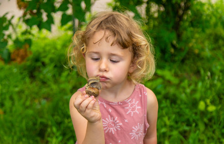 Child holding a snail on his hand. Selective focus.の写真素材