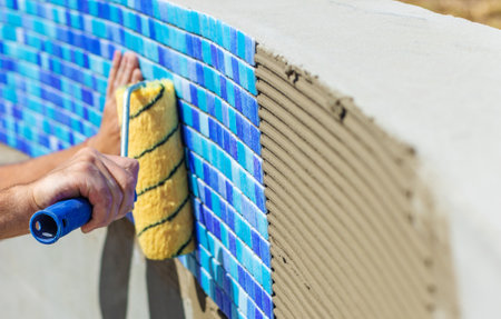 A man lays mosaic tiles in a swimming pool. Selective focus.の写真素材