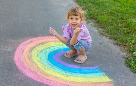 Children drawing with chalk on the asphalt. Selective focus.の写真素材
