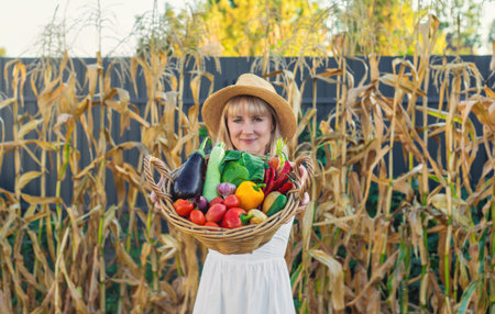 Woman with vegetables in the garden. Selective focus.の写真素材