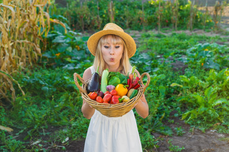 Woman with vegetables in the garden. Selective focus.の写真素材