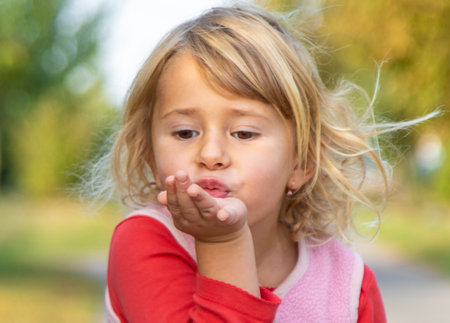Child blowing a kiss. Selective focus.の写真素材
