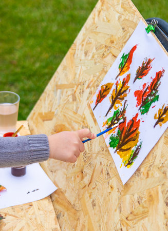 Child drawing autumn leaves. Selective focus.の写真素材