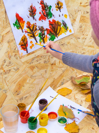 Child drawing autumn leaves. Selective focus.の写真素材