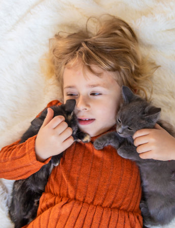 Child playing with kittens at home. Selective focus.の写真素材