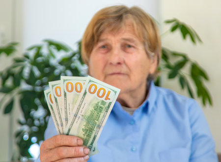 Old woman with money. Selective focus.の写真素材