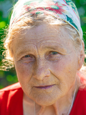 Portrait of an old woman in the garden. Selective focus.の写真素材