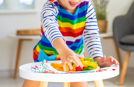 Child eats vegetables at home. Selective focus.の写真素材
