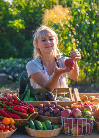 A woman farmer sells fruits and vegetables at a farmers market. Selective focus.の写真素材