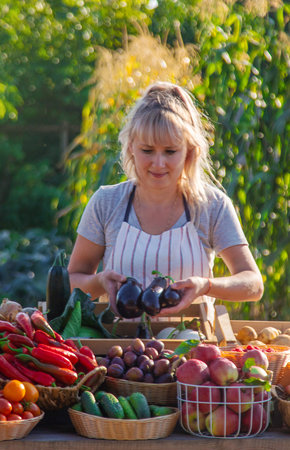A woman farmer sells fruits and vegetables at a farmers market. Selective focus.の写真素材