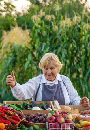 old woman farmer sells vegetables and fruits at the farmers market. Selective focus.の写真素材