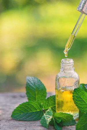 Peppermint essential oil in a bottle. selective focus.の写真素材