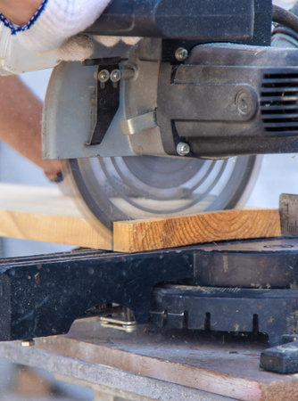 A man cuts wood with a sawmill. Selective focus.の写真素材