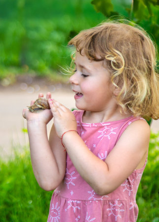 Child holding a snail on his hand. Selective focus.の写真素材