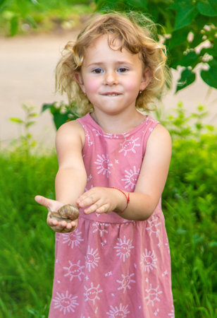 Child holding a snail on his hand. Selective focus.の写真素材