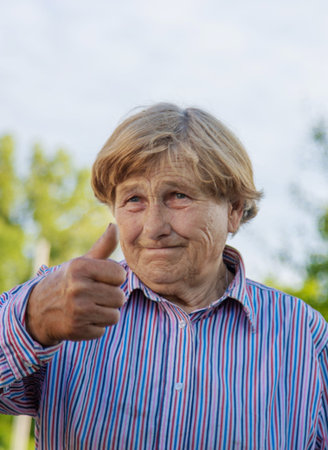 Old woman portrait in the garden. Selective focus.の写真素材