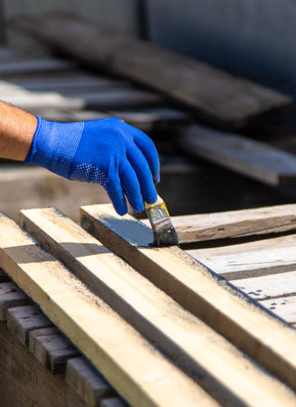 A man paints a board with paint. Selective focus.の写真素材