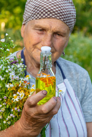 Old woman makes herbal tincture. Selective focus.の写真素材