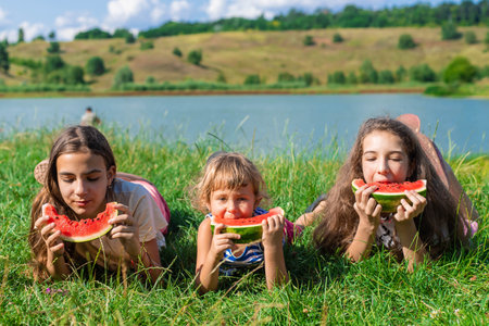 Children eating watermelon outdoors. Selective focus.の写真素材