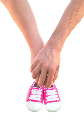 pregnant woman and man hold baby shoes. Selective focus.