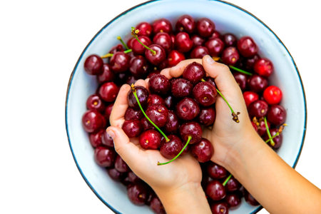 The child eats cherries in the garden. Selective focus.