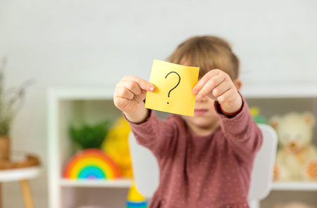 A child holds a question mark in his hands. Selective focus.の写真素材