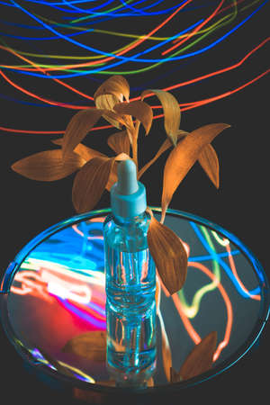Colorful Christmas Serum Advertising - a pipette bottle with neon lights reflections and bronze...
