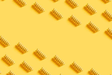 Wholegrain and healthy Italian pasta pattern on a modern fashionable yellow background. text copy. Kitchen culinary concept. Repeating flat layの写真素材