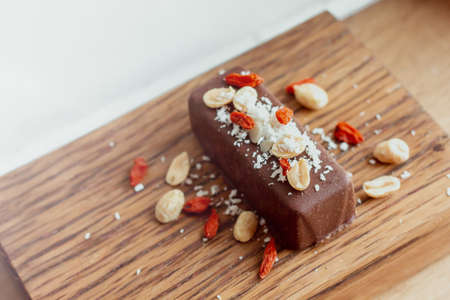 Vegan, gluten free carob chocolate bar with peanuts, goji berries, coconut and healthy micronutrients.の写真素材