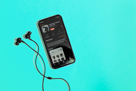 Moscow, Russia - February 16, 2021. Apple iPhone 12 Pro with Clubhouse application and Marshall headphones, blue background. Social media applicationのeditorial素材