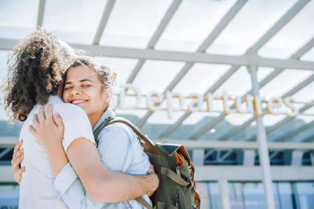 Lovely young couple hugging at the airport departures