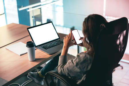 Woman using mobile devices at her workplace