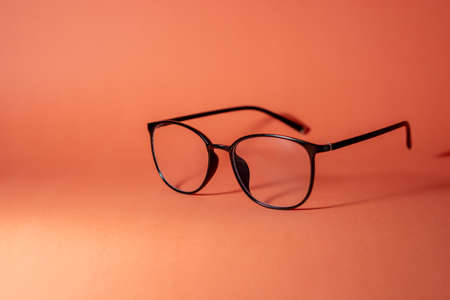 glasses on an orange background with copyspaceの写真素材