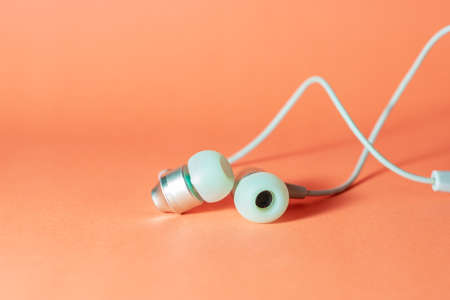 green headset on orange background with copy space