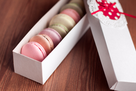 Colorful macaroons in the white present box on wooden backgroundの写真素材