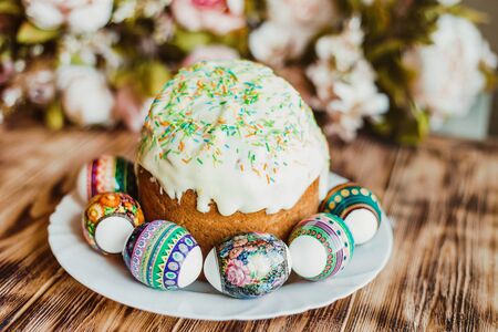 Glazed easter cake decorated with colored powder and with colorful eggs on wood background. Happy...