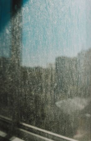 Dirty glass lit by the sun. Reflection on dirty glassの写真素材