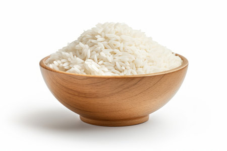 A bowl with uncooked white rice on white background. Concept of food staple, raw grains, cooking ingredient, healthy foodの素材