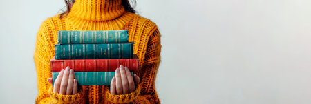 A woman holds books in her hands. Banner with copy spaceの素材