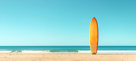 Surfboard erect on sandy beach under clear sky. Beachside surfboard. Concept of leisure sports, surf culture, coastal recreation, and sunny beach days. Copy space. Bannerの素材
