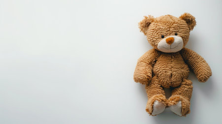 Plush brown toy bear sitting against a white background. Childhood companion. Concept of childhood,...