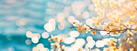 Blossoming white flowers against a bokeh ocean background. Delicate blooms with soft sunlight and...