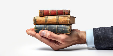 Vintage books in male hands. Man holding a stack of books in his palms. Concept of education, reading, knowledge, and library collection. White background.の写真素材