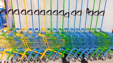 Dnipro, Ukraine - April 09, 2025: Colorful shopping carts arranged in pattern in supermarket aisle....