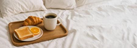 Breakfast in bed with coffee, croissant, toast, and orange slice on wooden tray - cozy morning routine and relaxation concept, Copy space. Wide Banner.の写真素材
