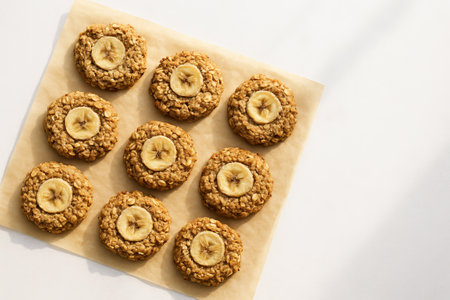 Delicious banana oatmeal cookies arranged on parchment paper with top-view composition. concept of homemade baking, simple recipes, healthy snack, copy space.の写真素材