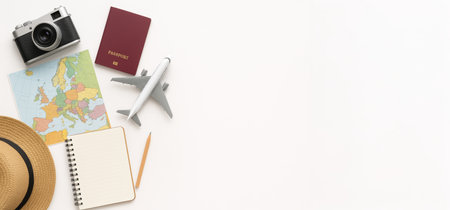 Travel planning flat lay with map, passport, camera, airplane model, and notebook on white background. concept of vacation preparation, adventure planning, travel essentials, white background, wide banner, copy space.の写真素材