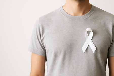 Man wearing gray t-shirt with white awareness ribbon for support and raising awareness. health support, symbol of hope, lung cancer, Parkinson's disease, blindness, copy space, white background.の写真素材