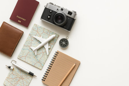 Travel planning essentials flat lay with passport, camera, map, and compass for perfect vacation preparation. concept of adventure, exploration, holiday organization. white background, copy space.の写真素材