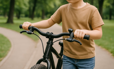 Caucasian boy riding a bicycle on a paved path in a sunny park. concept of childhood adventure, outdoor activity, young cyclist.の写真素材